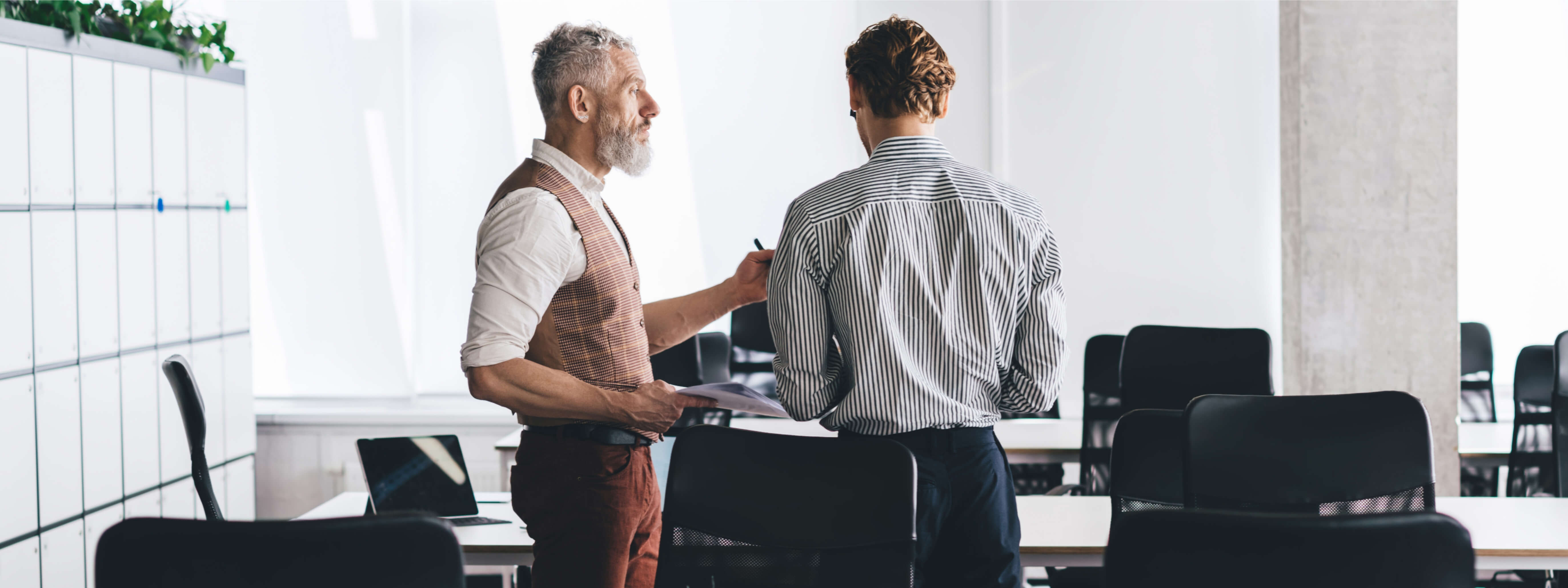 Two people taking a meeting in a modern office space.